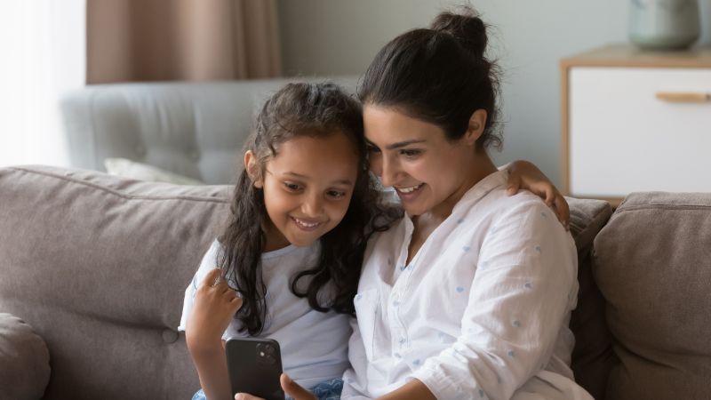 Mamá e hija disfrutan de una nueva aplicación en un teléfono
